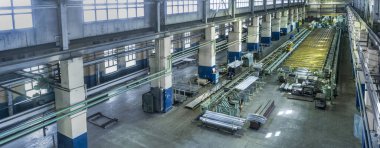 Fabrikadaki sanayi manzarası, makinelerle dolu büyük bir atölye, uzun profilli alüminyum metal ve kurusıkı imalatı için dönen ve esneyen fabrikalar..
