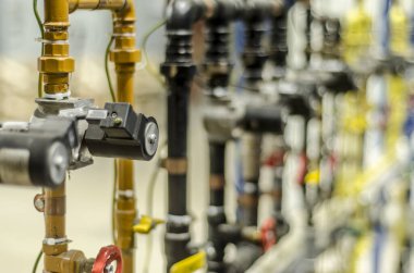 Fabrikadaki sanayi manzarası, gaz, sıvı, enjektör, vanalar ve basınç göstergeleriyle musluklar dağıtım sistemi..