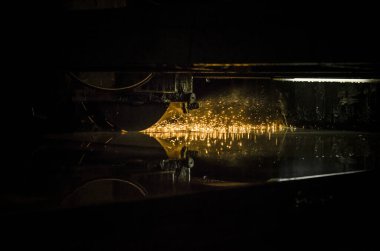 Fabrikadaki endüstriyel peyzaj, başlıktan gelen soğutma emülsiyonu, makinede dönen ya da değirmenleme sırasında düz kısmı kıvılcımlarla soğutur.