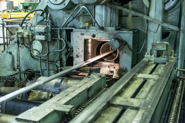 Industrial landscape at the plant, machines, rolling and stretching mills for the manufacture of aluminum metal and blanks in the form of long profiles.