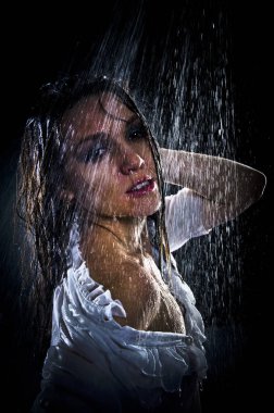 Kavramsal bakış açısı ve genç, şehvetli, güzel bir kızın sahnesi. Karanlık bir arka planda, bir su stüdyosunun arka planında, güçlü bir su püskürtüsünün altında yıkanan bir kadın..