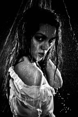 Kavramsal bakış açısı ve genç, şehvetli, güzel bir kızın sahnesi. Karanlık bir arka planda, bir su stüdyosunun arka planında, güçlü bir su püskürtüsünün altında yıkanan bir kadın..