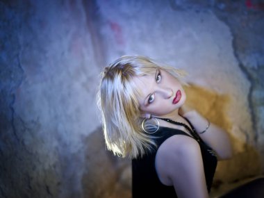 Modern ve genç, baştan çıkarıcı, duygusal, güzel bir sarışının kavramsal portresi. Koyu bir bluz içinde, yıkılmış bir binanın içinde, duvarların, tuğlaların içinde.