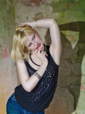 Modern ve genç, baştan çıkarıcı, duygusal, güzel bir sarışının kavramsal portresi. Koyu bir bluz içinde, yıkılmış bir binanın içinde, duvarların, tuğlaların içinde.