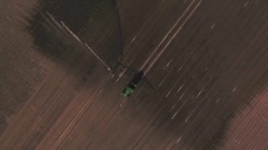 Traktör tarlada çalışıyor, marul fidanlığı, fıskiye spreyi, sulama makineleri, sulama. Hava görüntüleri, üst görünüm