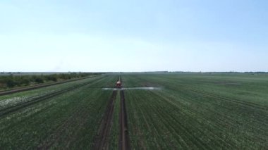Traktör dışarıda tarlada çalışıyor, sprey tarlasında. Kirlilik, kimyasallar, böcek ilaçları, böcek ilaçları. Hava görüntüleri