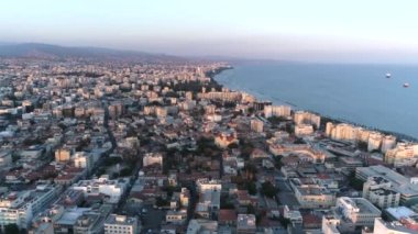 Günbatımında Limasol şehri, deniz manzaralı şehir manzarası, gemiler ve ufuk çizgisi, şafak, güzel ışık, altın saat. Hava görüntüleri