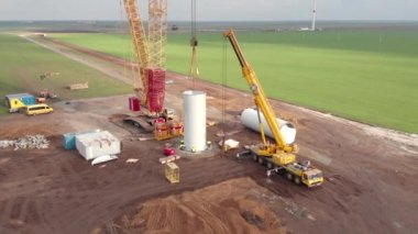 Rüzgâr enerjisi kule değirmeni inşaat halinde. Yel değirmeninin direğini monte eden kule. Yeşil, temiz, yenilenebilir enerji. Hava görüntüleri.