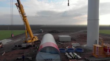 Rüzgar enerjisi kulesi inşaatı, yel değirmeni yapımı. Kule kısmının taşınması, sütunun montajı. Yeşil, temiz, yenilenebilir enerji. Hava görüntüleri.