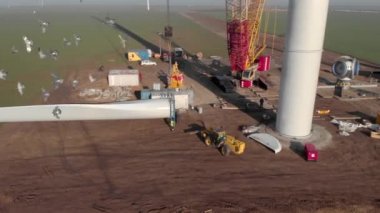 Rüzgâr enerjisi kule değirmeni inşaat halinde. Ulaşım, pervane bıçaklarının kurulumu. Yeşil, temiz, yenilenebilir enerji. Hava görüntüleri.