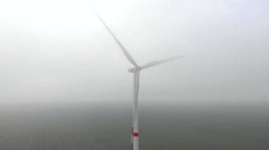 Rüzgâr enerjisi kulesi, elektrik güç yel değirmeni sis içinde dönüyor. Yeşil, temiz, yenilenebilir enerji. Hava görüntüleri.