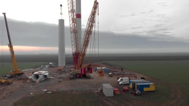 建設中の風力発電タワー工場の建設プロセス 風車の柱を組み立てる設置塔 クリーン 再生可能エネルギー 空中映像 — ストック動画