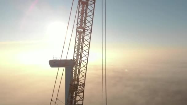 建設中の風力発電タワー工場の建設プロセス 霧の中で日の出 霧の朝 クリーン 再生可能エネルギー 空中映像 — ストック動画