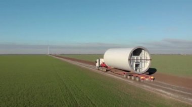 Rüzgar enerjisi kulesi inşaatı, yel değirmeni yapımı. Kule kısmının taşınması, sütunun montajı. Yeşil, temiz, yenilenebilir enerji. Hava görüntüleri.