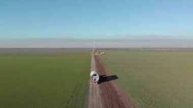 Rüzgar enerjisi kulesi inşaatı, yel değirmeni yapımı. Kule kısmının taşınması, sütunun montajı. Yeşil, temiz, yenilenebilir enerji. Hava görüntüleri.