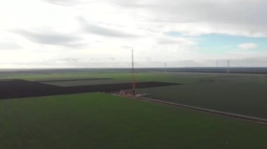 Rüzgâr enerjisi kule değirmeni inşaat halinde. Yel değirmeninin direğini monte eden kule. Yeşil, temiz, yenilenebilir enerji. Hava görüntüleri.