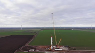 Rüzgâr enerjisi kule değirmeni inşaat halinde. Yel değirmeninin direğini monte eden kule. Yeşil, temiz, yenilenebilir enerji. Hava görüntüleri.