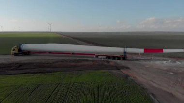 Rüzgâr enerjisi kule değirmeni inşaat halinde. Ulaşım, pervane bıçaklarının kurulumu. Yeşil, temiz, yenilenebilir enerji. Hava görüntüleri.