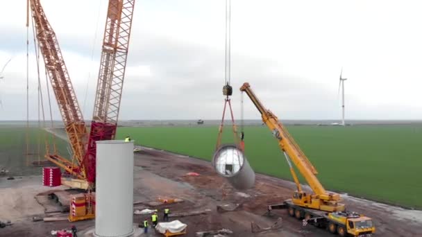 建設中の風力発電タワー工場の建設プロセス 風車の柱を組み立てる設置塔 クリーン 再生可能エネルギー 空中映像 — ストック動画