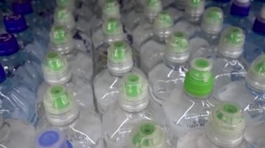Plastik şişeler, su, kapaklar, içecekler. Kamera hareket halinde üst görünümde
