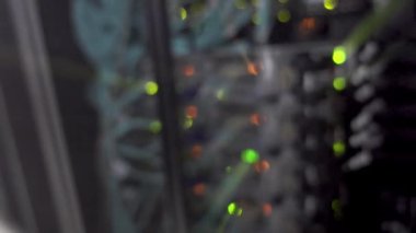 Yeşil Turuncu Bokeh LED ışıklar çalışan veri sunucusunun arka tarafında yanıp sönüyor. Video titreşim ve şok içeriyor.