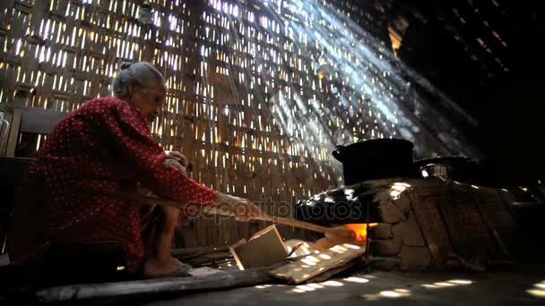 Cozimento feminino sênior no forno de tijolo — Vídeo de Stock