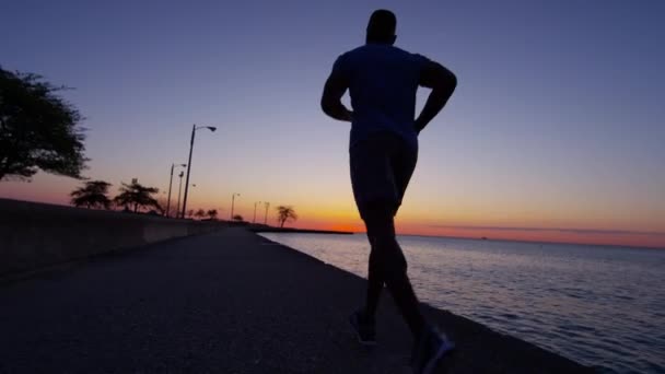 Чоловік біжить на сході сонця — стокове відео