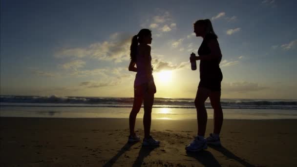 Vrouwtjes door de Oceaan in atletische sportkleding — Stockvideo