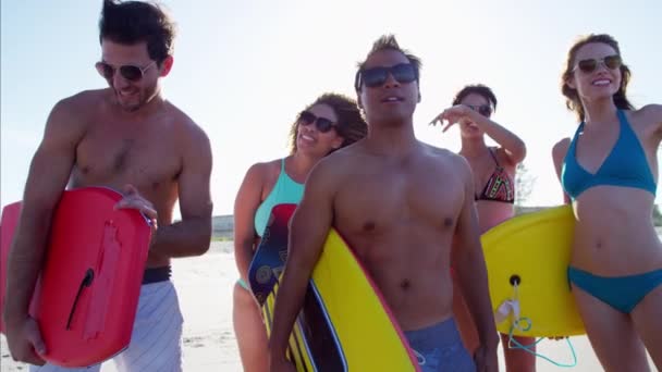 Amigos sosteniendo bodyboards en la playa — Vídeo de stock