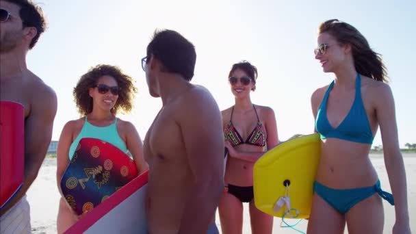 Machos y hembras con bodyboards en la playa — Vídeos de Stock