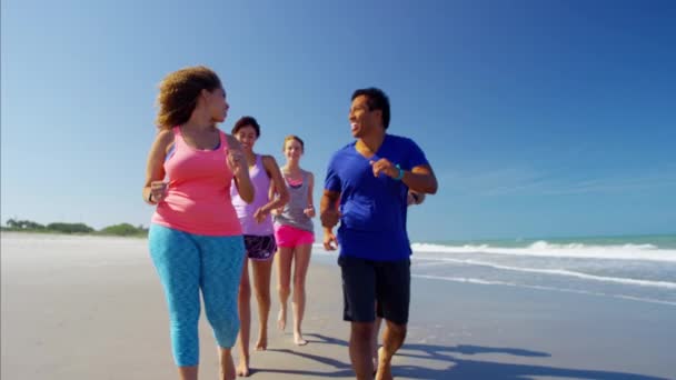 Männer und Frauen gehen am Strand spazieren — Stockvideo