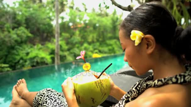 Fille relaxant avec du jus de noix de coco — Video