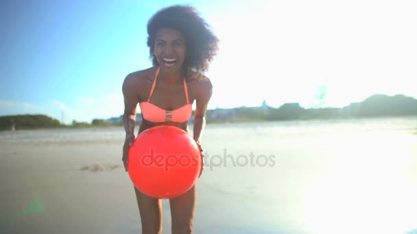 Женщина играет на пляже с мячом — стоковое видео