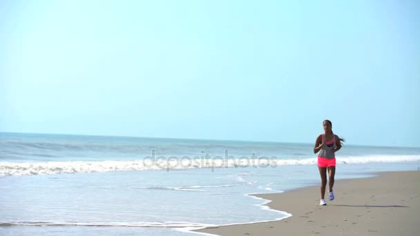 Woman jogging beside ocean — Stock Video