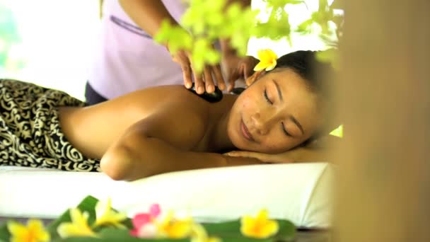 Hot stone massage by masseuse on female — Stock Video