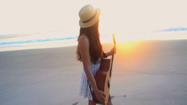 Девушка наслаждается закатом с гитарой — стоковое видео
