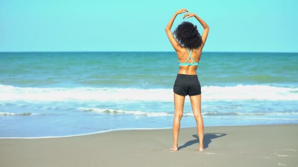 Vrouwelijke uitrekken op het strand — Stockvideo