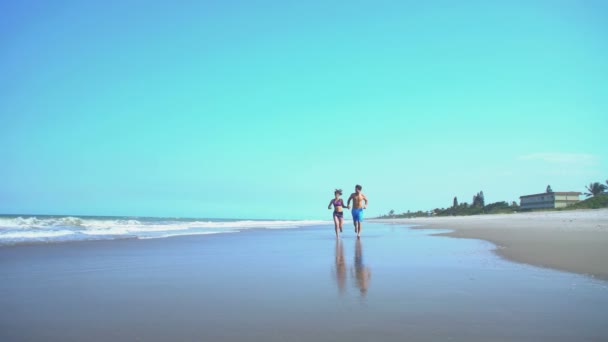 Masculino e feminino jogging na praia — Vídeo de Stock