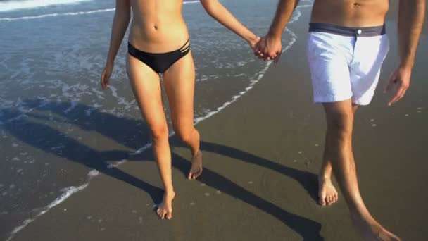 Мужчина и женщина прогуливаются по пляжу — стоковое видео