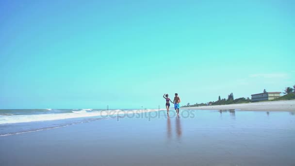 Mann und Frau joggen am Strand — Stockvideo