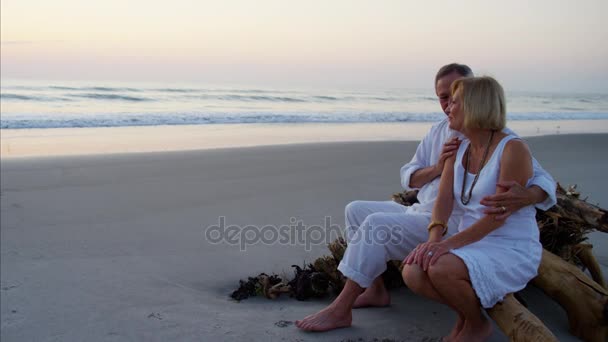 Casal desfrutando do pôr do sol na praia — Vídeo de Stock
