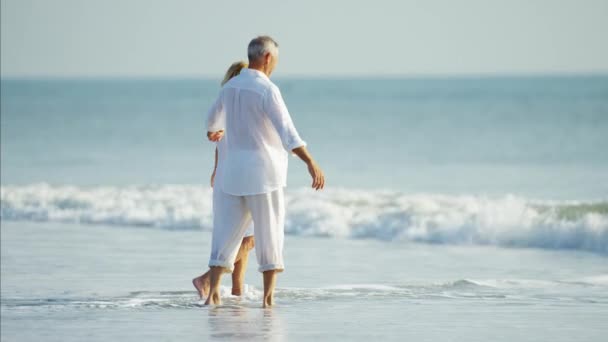 Paar genieten van golven op het strand — Stockvideo