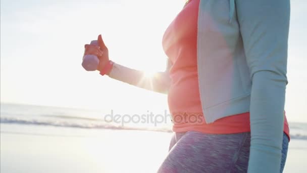 Hembra con pesas caminando por la playa — Vídeo de stock