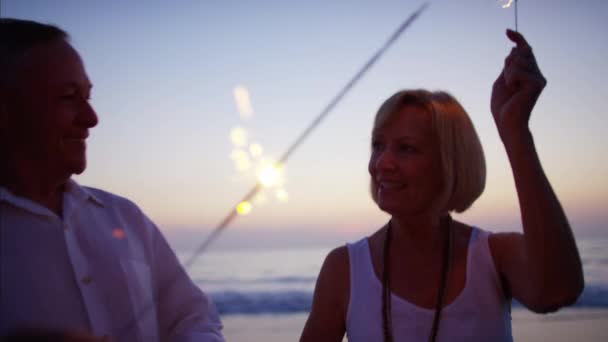 Couple enjoying sunset with sparklers — Stock Video