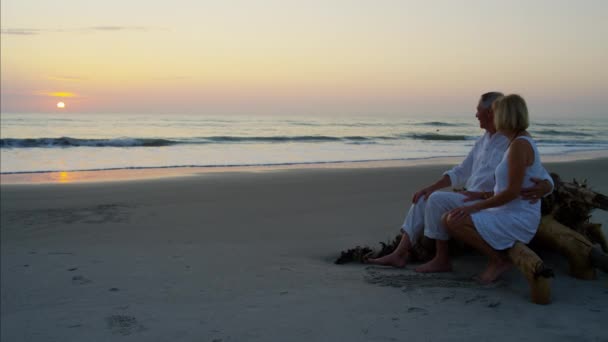 Пара насолоджується заходом сонця на пляжі — стокове відео