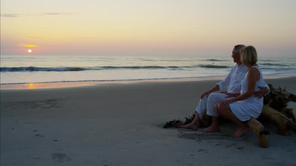 Casal desfrutando do pôr do sol na praia — Vídeo de Stock