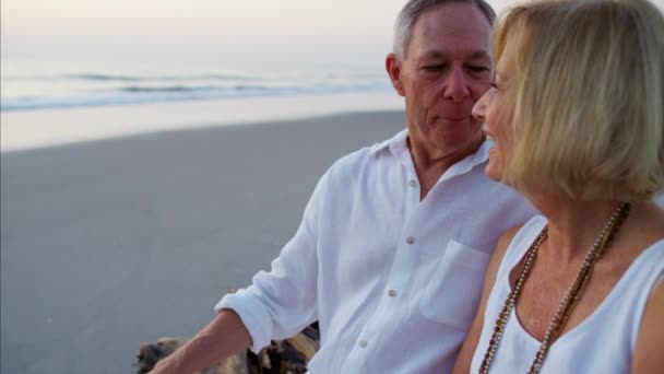 Casal desfrutando do nascer do sol na praia — Vídeo de Stock