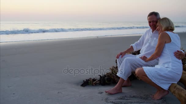 Casal desfrutando do pôr do sol na praia — Vídeo de Stock