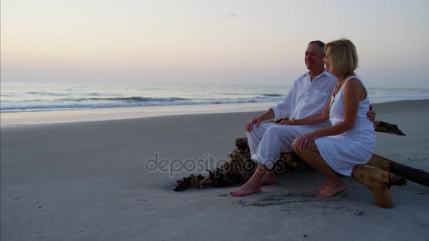 Casal desfrutando do pôr do sol na praia — Vídeo de Stock