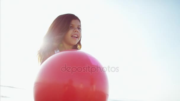 Flicka som leker på stranden med boll — Stockvideo